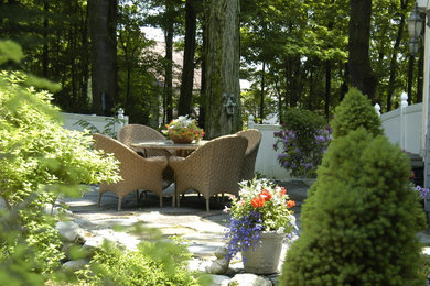 Inspiration for a mid-sized transitional partial sun backyard stone landscaping in Boston.