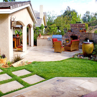 Geometrischer, Mittelgroßer Mediterraner Garten im Herbst, hinter dem Haus mit Kamin, direkter Sonneneinstrahlung, Natursteinplatten und Steinzaun in San Diego