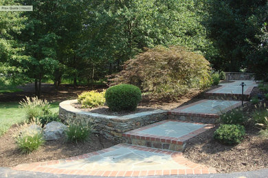 Diseño de jardín moderno de tamaño medio en patio trasero con exposición parcial al sol y adoquines de piedra natural