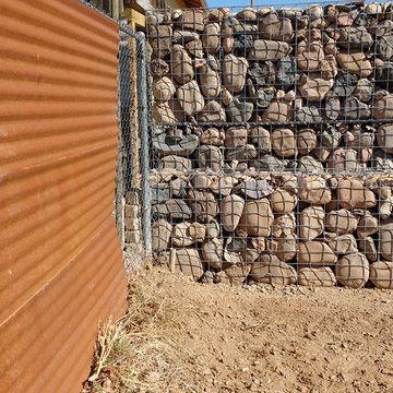 Backyard wall/fence and retaining wall in front supporting hillside construction