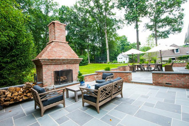Example of a large classic backyard stone patio design in Baltimore with a fire pit