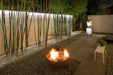 Design ideas for a contemporary backyard gravel landscaping in Houston with a fire pit.