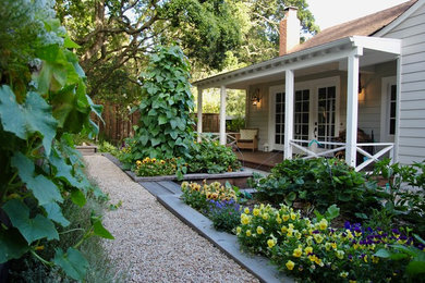 Imagen de jardín de estilo de casa de campo de tamaño medio en patio delantero con gravilla, jardín de macetas y exposición reducida al sol