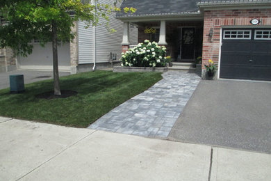 Design ideas for a mid-sized modern full sun front yard brick landscaping in Ottawa.