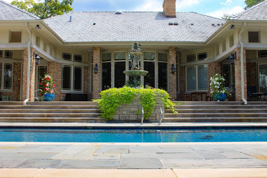 Medium sized classic back formal full sun garden for summer in Chicago with natural stone paving and a water feature.