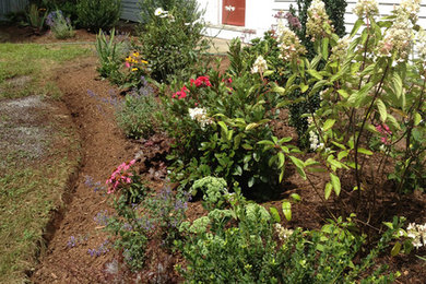 Inspiration for a mid-sized farmhouse full sun front yard mulch landscaping in Bridgeport for summer.
