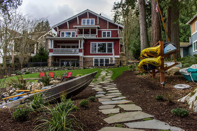 Photo of a mid-sized traditional partial sun backyard stone landscaping in Seattle.