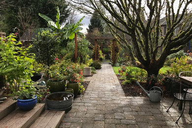 Diseño de jardín clásico renovado en patio trasero con adoquines de hormigón