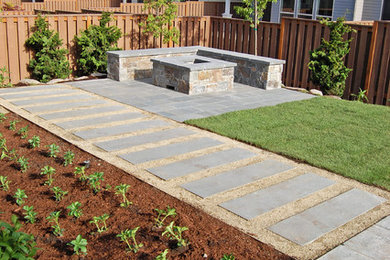 Small contemporary back partial sun garden in Portland with a fire feature and natural stone paving.