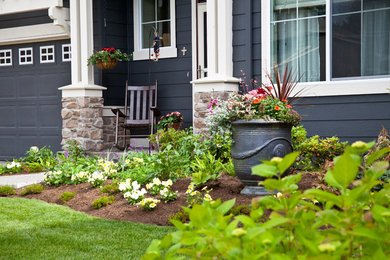 This is an example of a mid-sized farmhouse front yard concrete paver landscaping in Seattle.