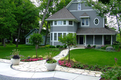 Inspiration för en stor vintage trädgård framför huset, med en trädgårdsgång och naturstensplattor