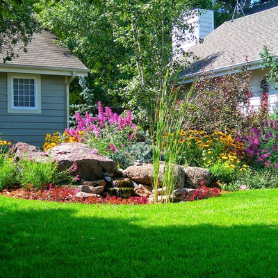 This is an example of a mid-sized traditional partial sun front yard mulch water fountain landscape in Other.