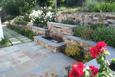 Inspiration for a large traditional full sun backyard stone retaining wall landscape in Other for summer.