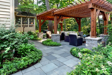 Inspiration for a large traditional shade backyard stone landscaping in Chicago with a pergola for summer.