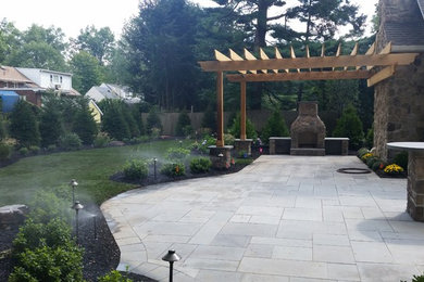 Foto de jardín tradicional de tamaño medio en patio trasero con jardín francés, brasero y adoquines de piedra natural