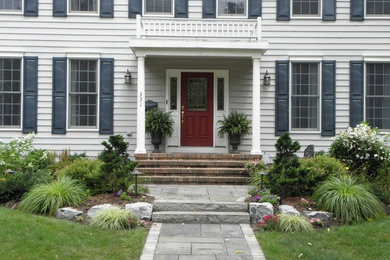This is an example of a medium sized contemporary front partial sun garden in New York with natural stone paving.