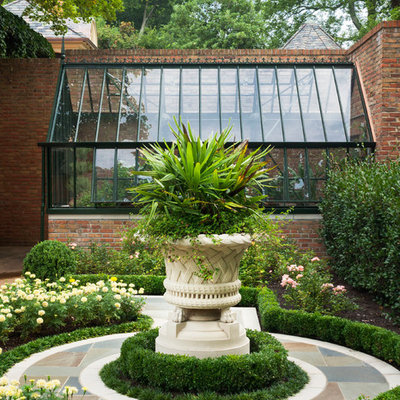 Inspiration for a mid-sized traditional partial sun courtyard stone landscaping in Other.