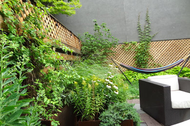 Imagen de jardín romántico de tamaño medio en patio trasero con jardín francés, jardín de macetas, exposición parcial al sol y adoquines de piedra natural