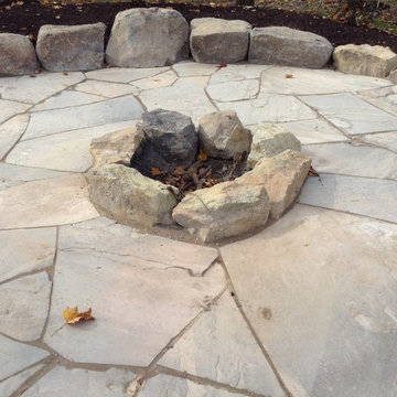Boulder fire pit with irregular custom cut flagstone