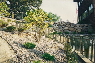 Foto de jardín clásico de tamaño medio en patio trasero con muro de contención y adoquines de hormigón