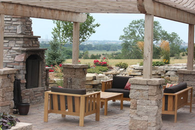 Imagen de jardín de estilo americano grande en patio trasero con exposición total al sol, adoquines de piedra natural y brasero