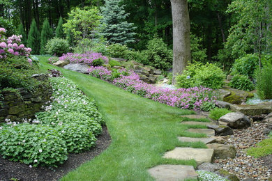 Inspiration for a large transitional partial sun backyard stone retaining wall landscape in Cleveland for summer.