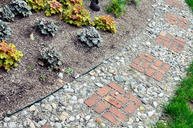 Diseño de camino de jardín tradicional de tamaño medio en verano en patio lateral con jardín francés, adoquines de piedra natural y exposición parcial al sol