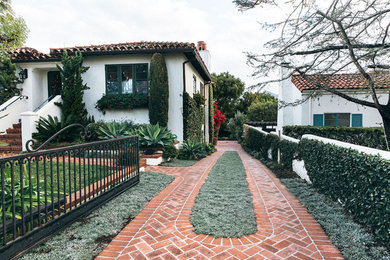 This is an example of a mid-sized mediterranean partial sun front yard brick driveway in Santa Barbara for summer.