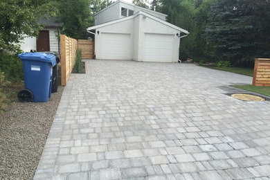 Photo of a mid-sized traditional front yard brick driveway in Calgary.