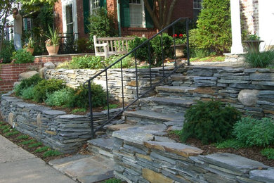 Inspiration for a mid-sized transitional shade front yard stone retaining wall landscape in DC Metro for spring.