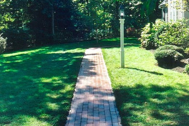 Photo of a mid-sized traditional side yard brick garden path in Boston.