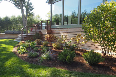 Imagen de jardín moderno de tamaño medio en primavera en patio delantero con exposición total al sol y entablado