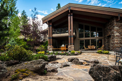 Photo of a huge rustic full sun backyard stone landscaping in Other with a fire pit.