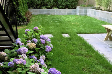 Imagen de jardín contemporáneo de tamaño medio en patio trasero con exposición parcial al sol y adoquines de piedra natural