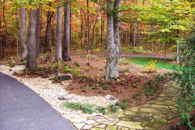 Modelo de jardín tradicional renovado en otoño en patio delantero con exposición parcial al sol y adoquines de piedra natural