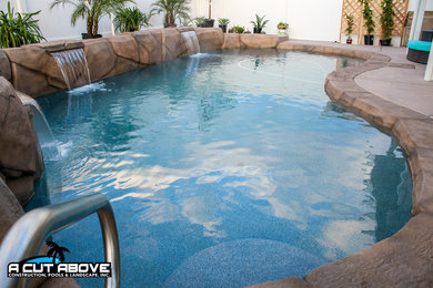 Diseño de piscina natural tradicional de tamaño medio en patio trasero con suelo de hormigón estampado