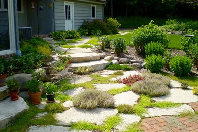 This is an example of a mid-sized traditional partial sun front yard stone landscaping in Milwaukee.