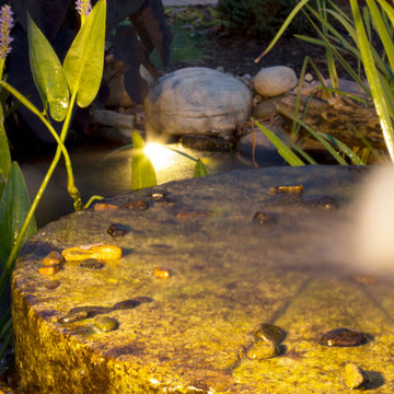 Bubbling Millstone highlighted in pond with LED lighting in Fountain City area o