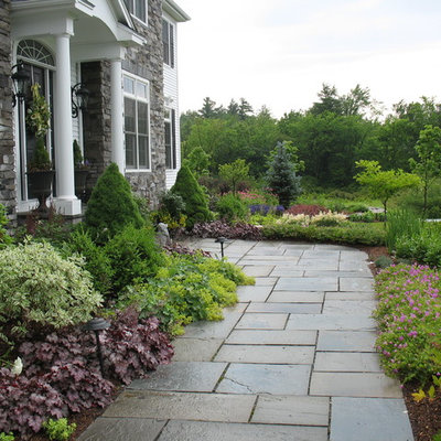 This is an example of a traditional full sun front yard stone garden path in Burlington.