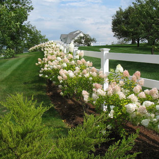 This is an example of an expansive country backyard full sun formal garden in Burlington with a garden path.