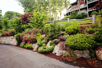 Inspiration for a mid-sized traditional full sun hillside stone retaining wall landscape in Charlotte for summer.