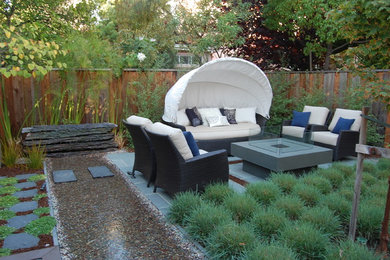 Imagen de jardín actual pequeño en patio trasero con exposición parcial al sol y adoquines de piedra natural