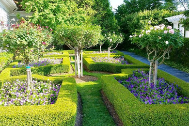 Diseño de jardín clásico grande en patio trasero con jardín francés, exposición parcial al sol y adoquines de hormigón