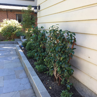 Geometrischer, Kleiner, Halbschattiger Klassischer Garten im Sommer, hinter dem Haus mit Kamin und Natursteinplatten in Seattle