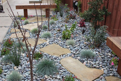 Diseño de jardín en patio trasero con adoquines de piedra natural