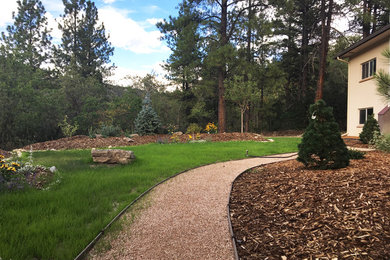 Foto de jardín de estilo americano de tamaño medio en verano en patio trasero con exposición parcial al sol y adoquines de piedra natural