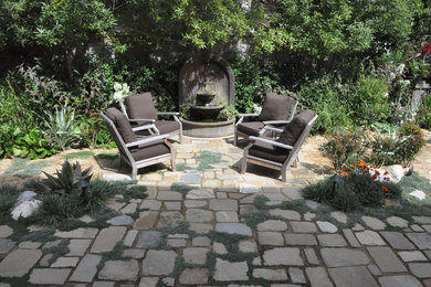 Photo of a mid-sized traditional partial sun backyard stone landscaping in San Francisco.