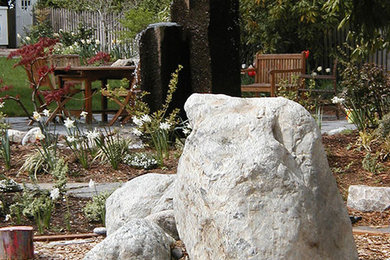 Diseño de jardín actual grande en patio delantero con fuente, exposición parcial al sol y adoquines de piedra natural