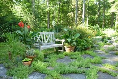 This is an example of a large rustic back full sun garden for summer in New York with a garden path and natural stone paving.