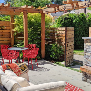 Mittelgroßer Garten neben dem Haus mit Kamin, direkter Sonneneinstrahlung und Betonplatten in Seattle
